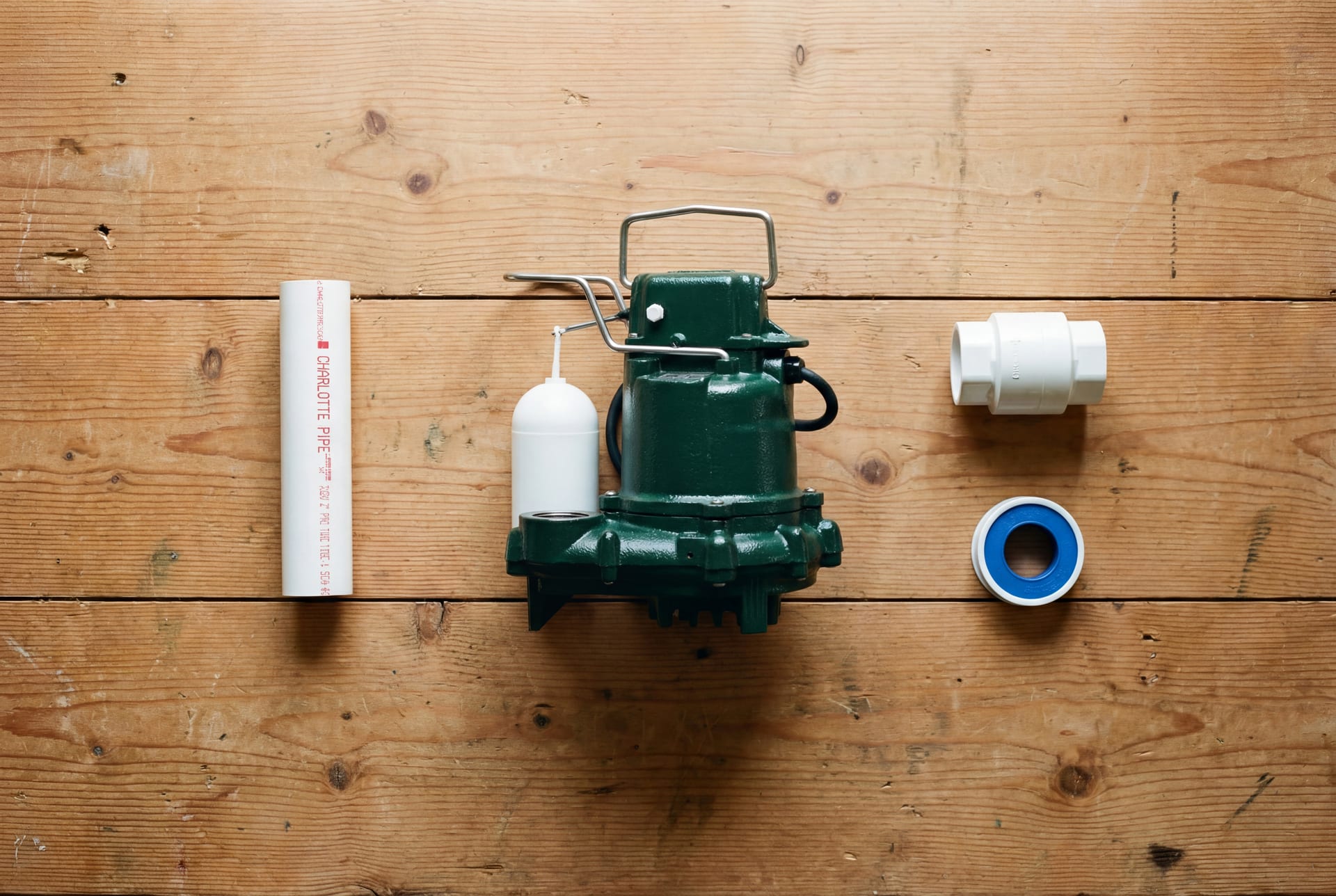 Sump pump install kit laid out on a workshop bench